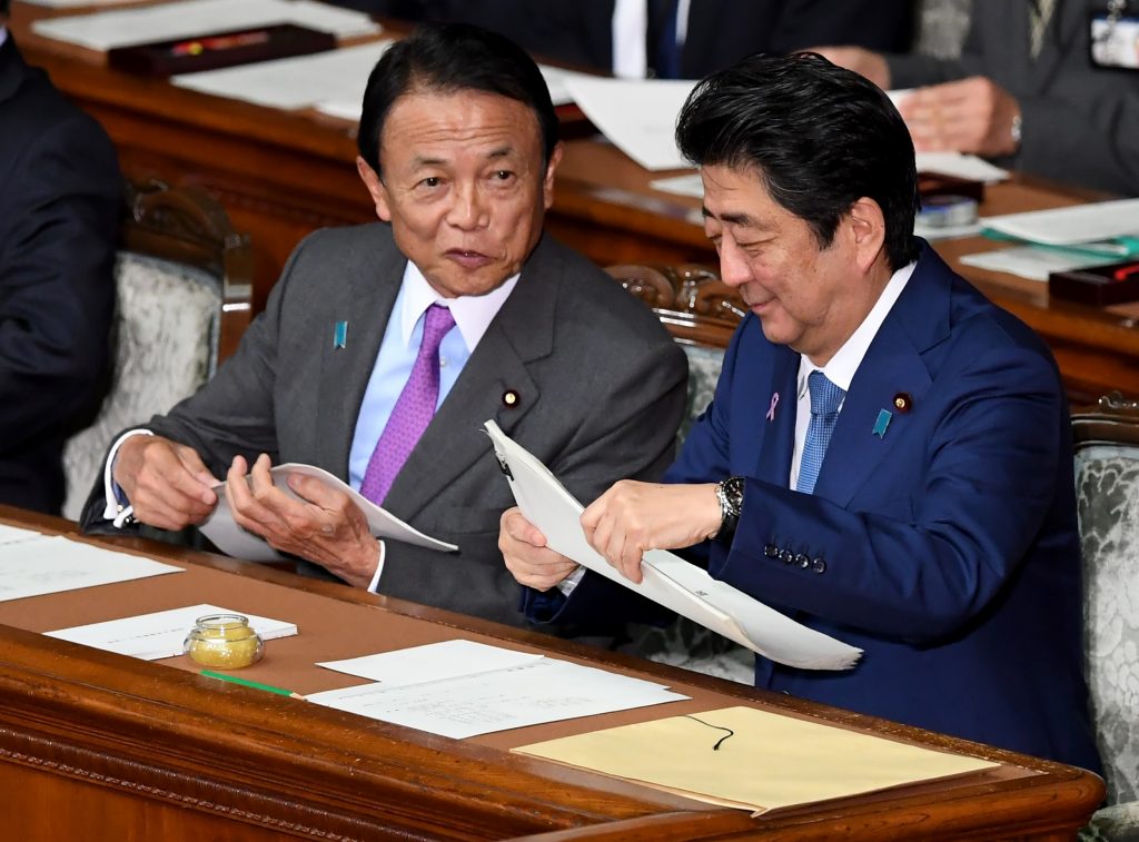 Japanese Prime Minister Shinzo Abe (R) listens to vice Prime Minister and Finance Minister Taro Aso (L) prior to Prime Minister Abe’s policy speech at the lower house of the parliament in Tokyo on November 17, 2017. (AFP)