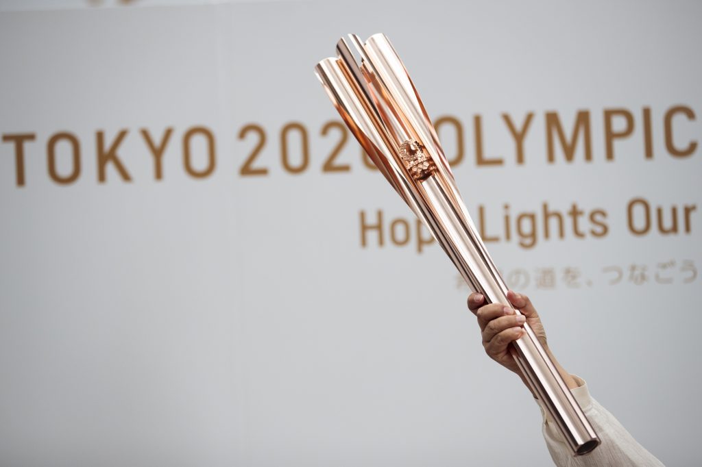 A woman holds the Tokyo 2020 Olympic Games torch during a public event in Tokyo on June 1, 2019. (AFP)