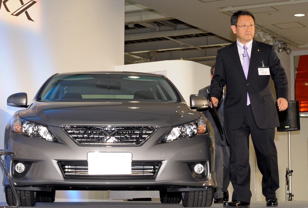 Toyota Motors President Akio Toyoda (R) walks beside the company’s new Mark X sedan during a press preview in Tokyo on October 19, 2009. (AFP)