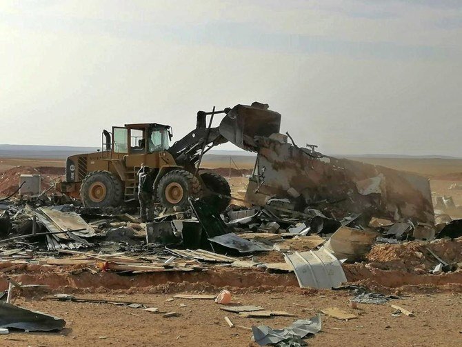 Fighters from the Kataib Hezbollah inspect the destruction at their headquarters after a US airstrike in Qaim, Iraq. (AP)