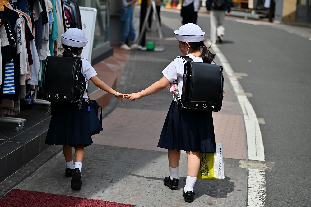 School students walk on a street in Tokyo's Harajuku district on June 4, 2019. (AFP/file)