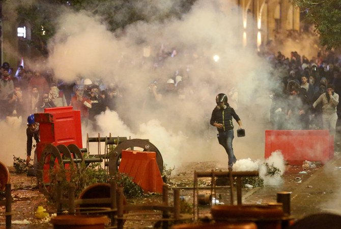 Anti-government protesters clash with the riot police, during a protest near the parliament square, in downtown Beirut, Lebanon, on Dec. 15, 2019. (AP Photo/Hussein Malla)