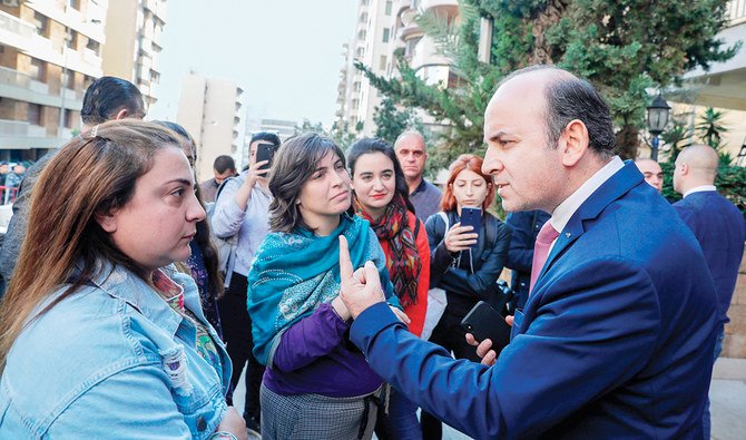 Lebanese demonstrators argue with a PML representative, right, outside in the neighborhood of Tallet Al-Khayat in Beirut on Sunday. (AFP)