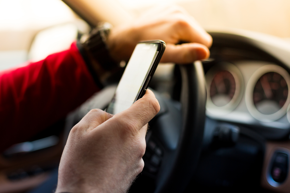 Drivers of standard vehicles found using smartphones or mobile phones while driving will face a fine of 18,000 yen. (Shutterstock)