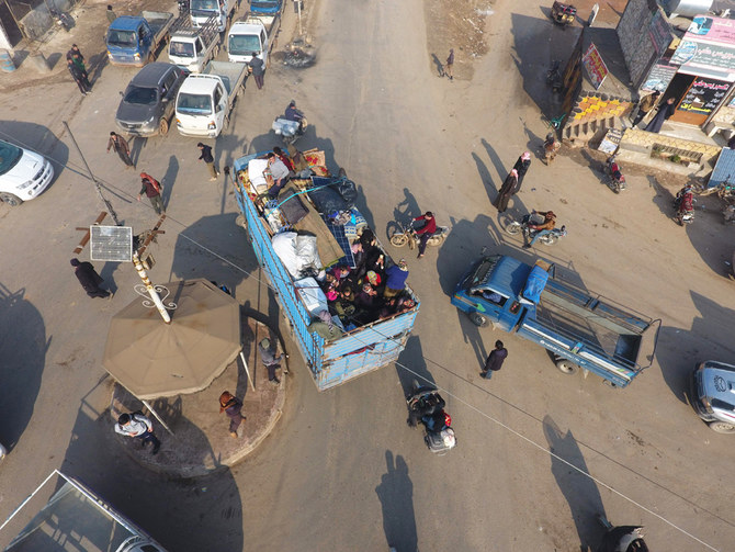 An aerial photo taken on Dec. 22, 2019, shows Syrian families fleeing the village of Hazano, about 20 km northwest of the city of Idlib, towards the Syrian-Turkish border. (AFP / Aref Tammawi)