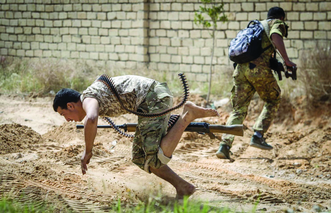 Fighters loyal to the Tripoli administration run for cover during clashes with forces loyal to eastern commander Gen. Khalifa Haftar south of Tripoli. (AFP)