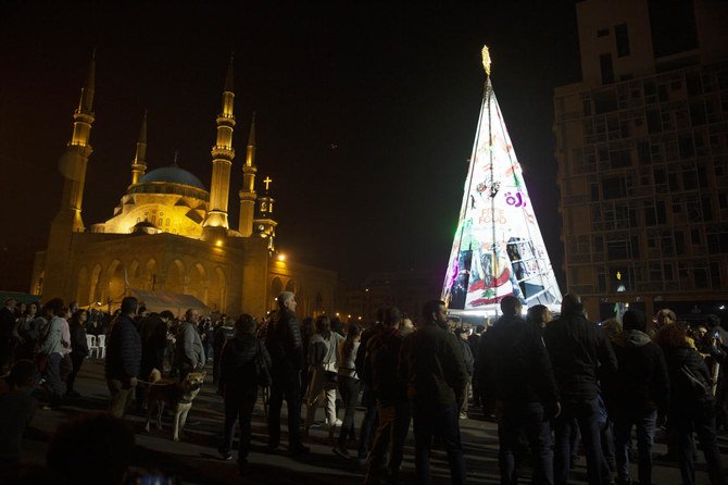 Anti-government protesters gather around their Christmas tree, which incorporates protest iconography and slogans and personal messages, in downtown Beirut on Saturday, Dec. 21, 2019. (AP)