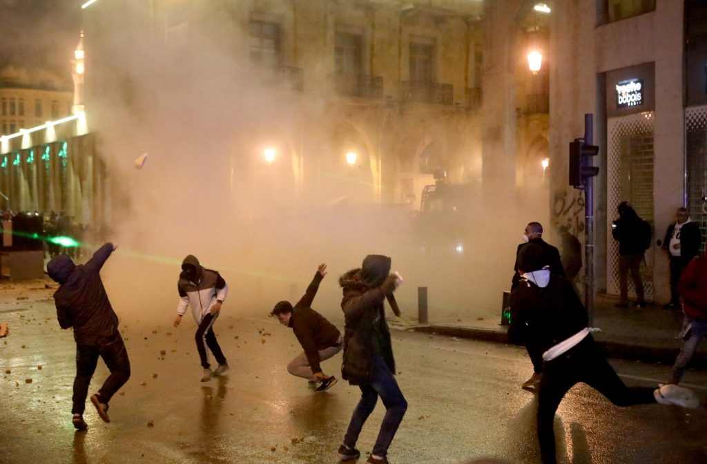 Lebanese protesters hurl stones at riot police guarding a road leading to parliament in central Beirut, Lebanon on Jan. 19. (AFP)