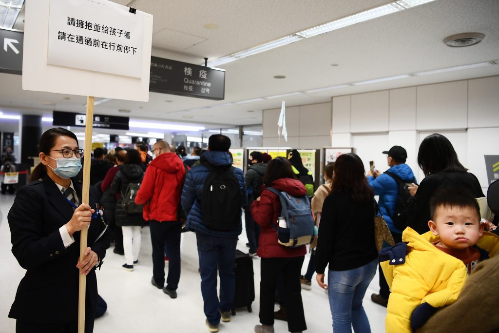 Passengers who arrived on one of the last flights from Wuhan, China, walk through a health screening station at Narita airport in Chiba prefecture, outside Tokyo, on Jan. 23, 2020. (AFP)