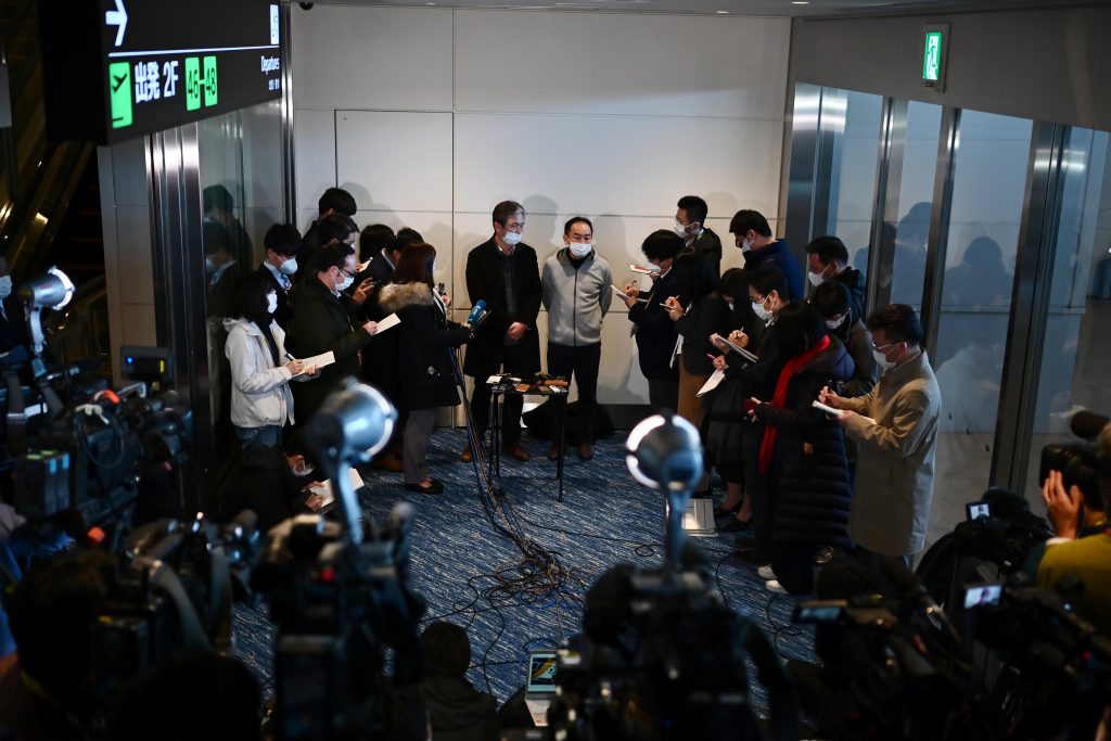 Takeo Aoyama (centre L) and Takayuki Kato (centre R), Japanese businessmen residing in Wuhan, speak to journalists during a press conference following their charter flight arranged by Japan's government to evacuate its citizens from the Chinese city, at a terminal building after disembarking their aircraft at Haneda airport in Tokyo on January 29, 2020. (AFP)
