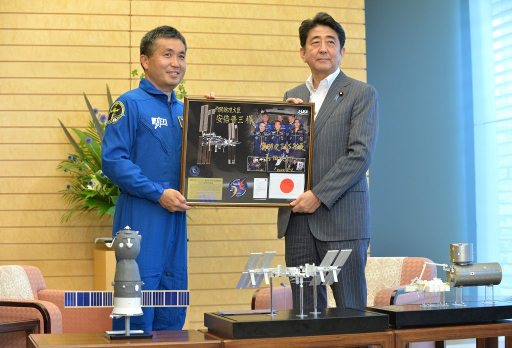 Astronaut Koichi Wakata (L) presents his memorial flight panel to Japanese Prime Minister Shinzo Abe in Tokyo, Aug. 7, 2014. (AFP)