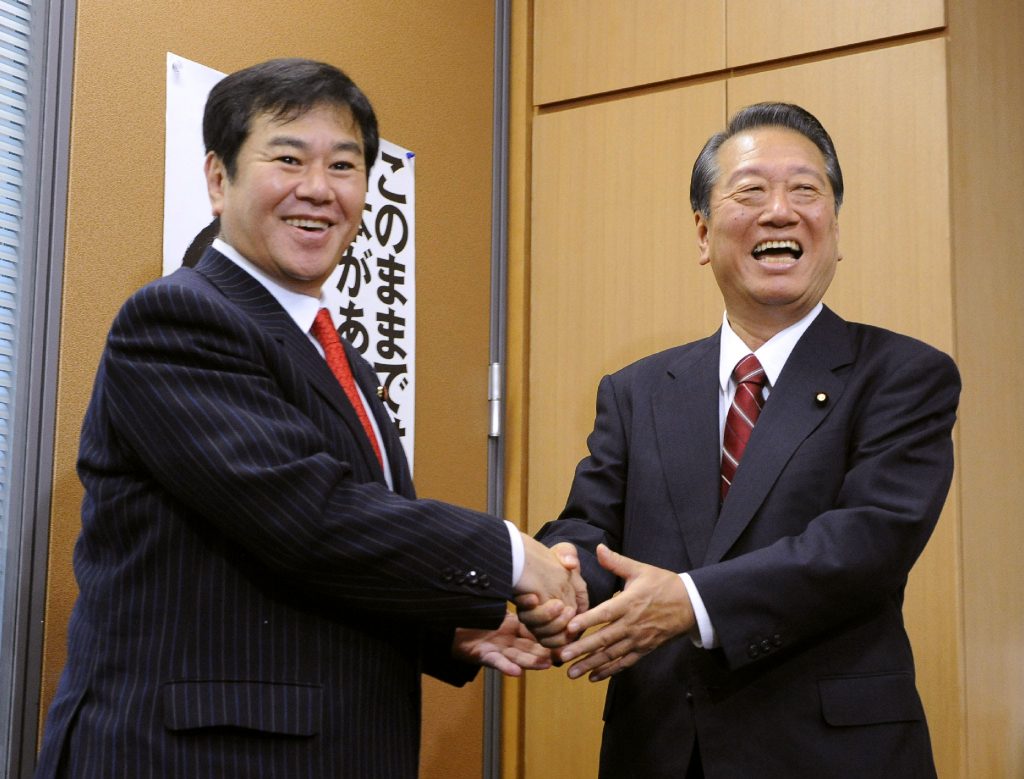 Kazuhiro Haraguchi, parliamentary affairs chief of the Democratic Party for the People Kazuhiro Haraguchi (L) shakes hands with Japanese politician Ichiro Ozawa (R) in Tokyo, Sep. 13, 2010. (AFP)
