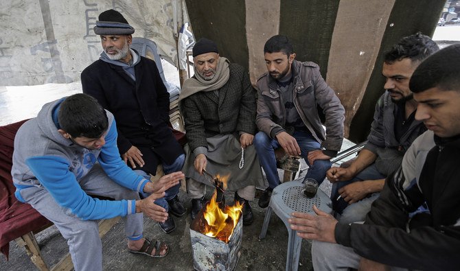 Palestinians warm themselves up in Gaza, which is called an open air prision because of Israeli restrictions. (AFP)