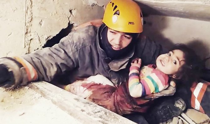 A handout picture taken and released on January 26, 2020 by the Ankara Metropolitan Municipality press office shows a rescue officer with a 2.5-year-old (Nusra) being rescued under the rubble of a building that collapsed in Elazig following January 24's earthquake. (AFP)