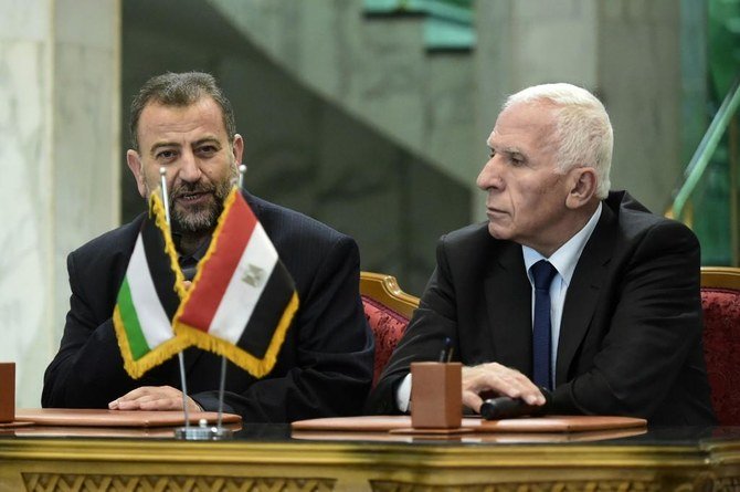 Fatah and Hamas are rival Palestinian factions. Fatah’s Azzam Al-Ahmad (R) and Saleh Al-Aruri (L) of Hamas talk to journalists after signing a reconciliation deal in Cairo in 2017. (File/AFP)