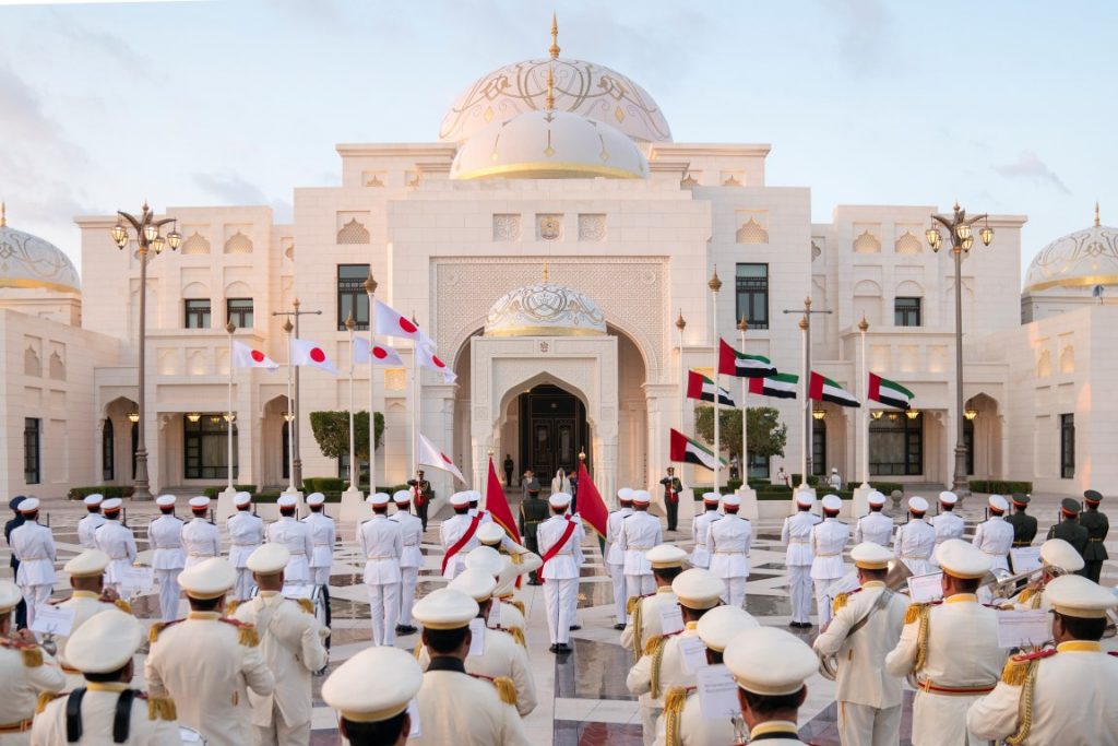 Sheikh Mohamed and the Japanese Prime Minister stand as a band plays the national anthems of the two countries. (WAM)