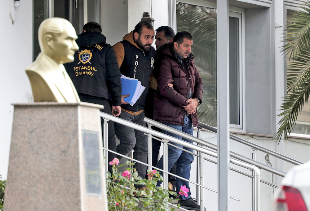 Turkish police officers escort suspects, accused of involvement of Nissan's former CEO Carlos Ghosn passage through Istanbul, after he fled Japan, in Istanbul, Friday. (AP)