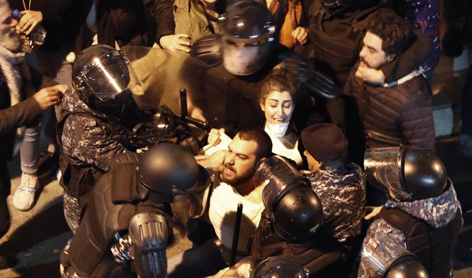 Riot police arrest anti-government protesters who were protesting outside a police headquarters on Wednesday night. (AP)