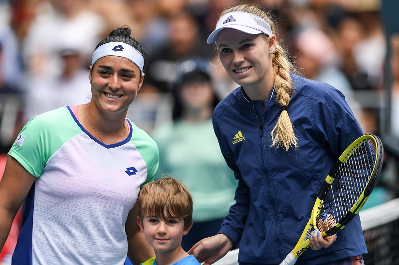 Tunisia's Ons Jabeur (left) and Denmark's Caroline Wozniacki (right) pose for photographs with a ball boy before their women's singles match on day five of the Australian Open tennis tournament in Melbourne on January 24, 2020. (AFP)