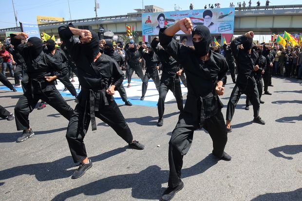 Iraqi Shiite fighters from the Iran-backed Kata’ib Hezbollah militia during a military parade in Baghdad. (AFP)