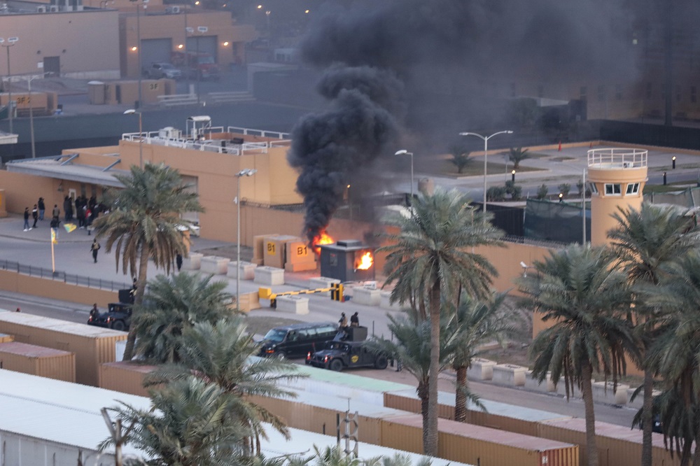 A handout picture received from the US embassy in Iraq on December 31, 2019, shows smoke billowing from a sentry box at an entrance of the embassy in the capital Baghdad. (AFP)