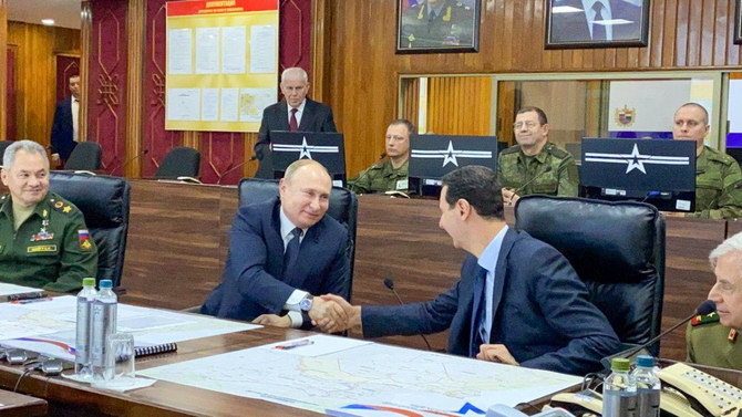 A handout picture released by the official Syrian presidency Telegram page on January 7, 2020 shows President Bashar al-Assad (right) shaking the hand of his Russian counterpart Vladimir Putin at the headquarters of the Russian forces in the Syrian capital Damascus. (AFP)