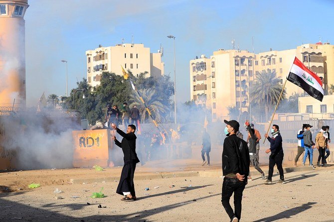 US Embassy security men use tear gas to disperse protesters and militia fighters during a protest to condemn air strikes on bases belonging to Hashd al-Shaabi (paramilitary forces), outside the US Embassy in Baghdad, Iraq Jan. 1, 2020. (Reuters/Thaier al-Sudani)