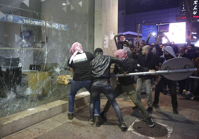 Anti-government protesters smash a bank widow, during ongoing protests against the Lebanese central bank's governor and against the deepening financial crisis, at Hamra trade street, in Beirut. (AP)