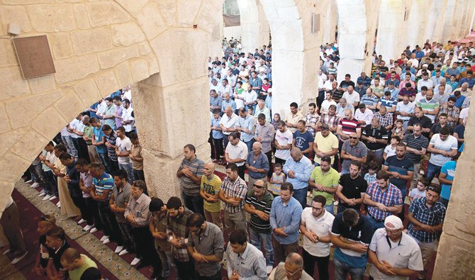 Palestinians hold Friday prayers in the Marwani Prayer Room, also called Solomon’s Stables, located under the southeastern corner of the raised platform, which holds the Dome of the Rock and Al-Aqsa Mosque in Jerusalem’s Old City. A fire broke out at the sacred site. (AFP)