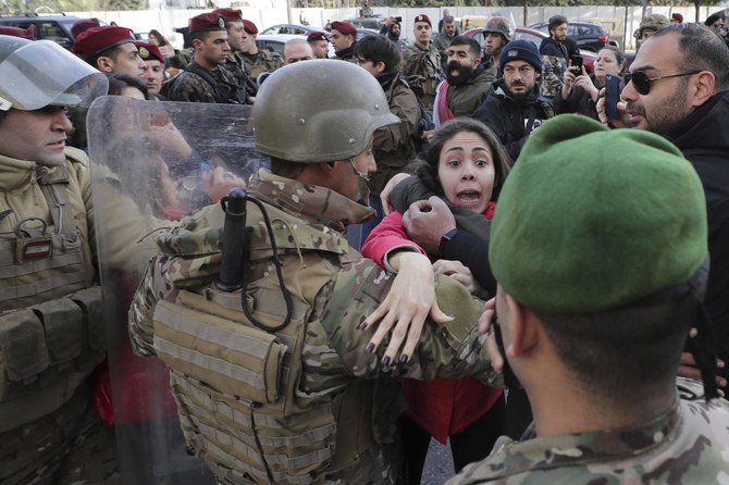 An anti-government protester scuffles with an army official during a demonstration outside the parliament building in downtown Beirut on Monday, Jan. 27, 2020. (AP)