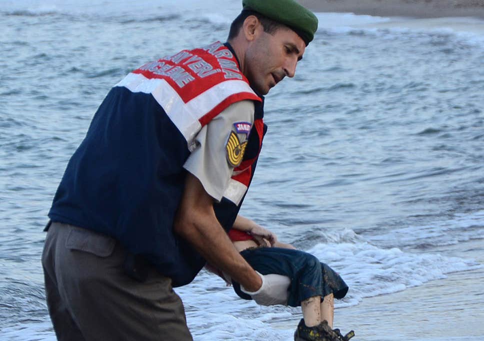 A Turkish police officer carries the body of Aylan Kurdi. (Getty Images)