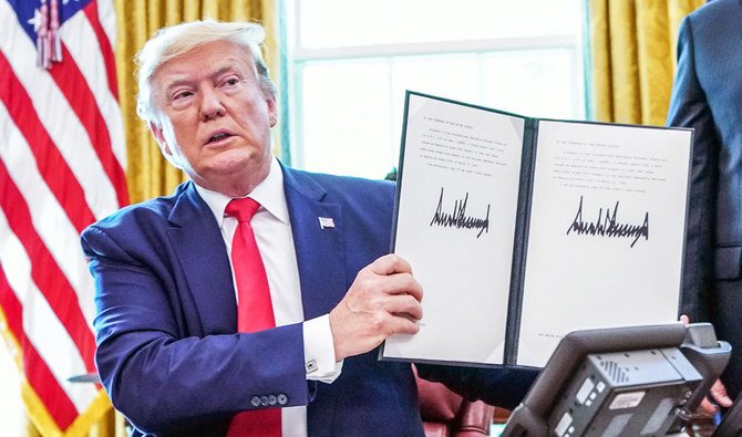 In this file photo taken on June 24, 2019, US President Donald Trump signs sanctions against Iran’s supreme leader at the White House in Washington, DC. Trump said on Friday that Iranian military commander Qassem Soleimani should have been killed long before. (AFP)