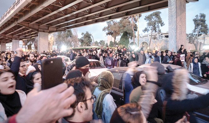 Video footage has emerged of protesters tearing down Soleimani’s photos. (Reuters)