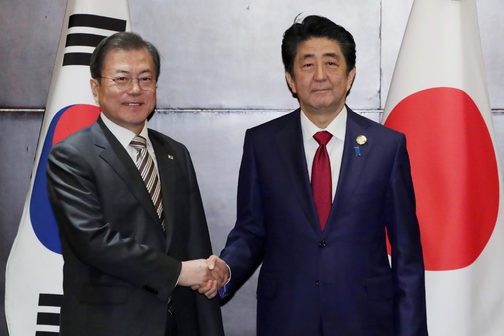South Korea's President Moon Jae-in (L) shakes hands with Japan's Prime Minister Shinzo Abe during their meeting in Chengdu, southwestern China's Sichuan province on Dec. 24, 2019 (AFP)