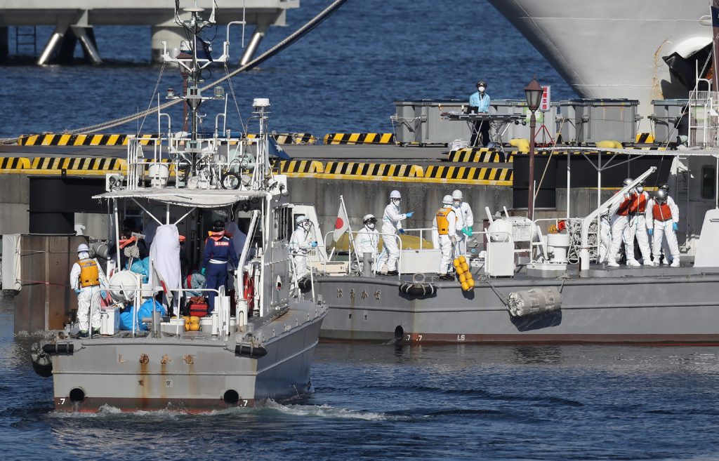 Workers in protective gear are seen on the Japan Coast Guard boats in Yokohama bringing patients from the Diamond Princess cruise ship, Feb. 5, 2020. (AFP)