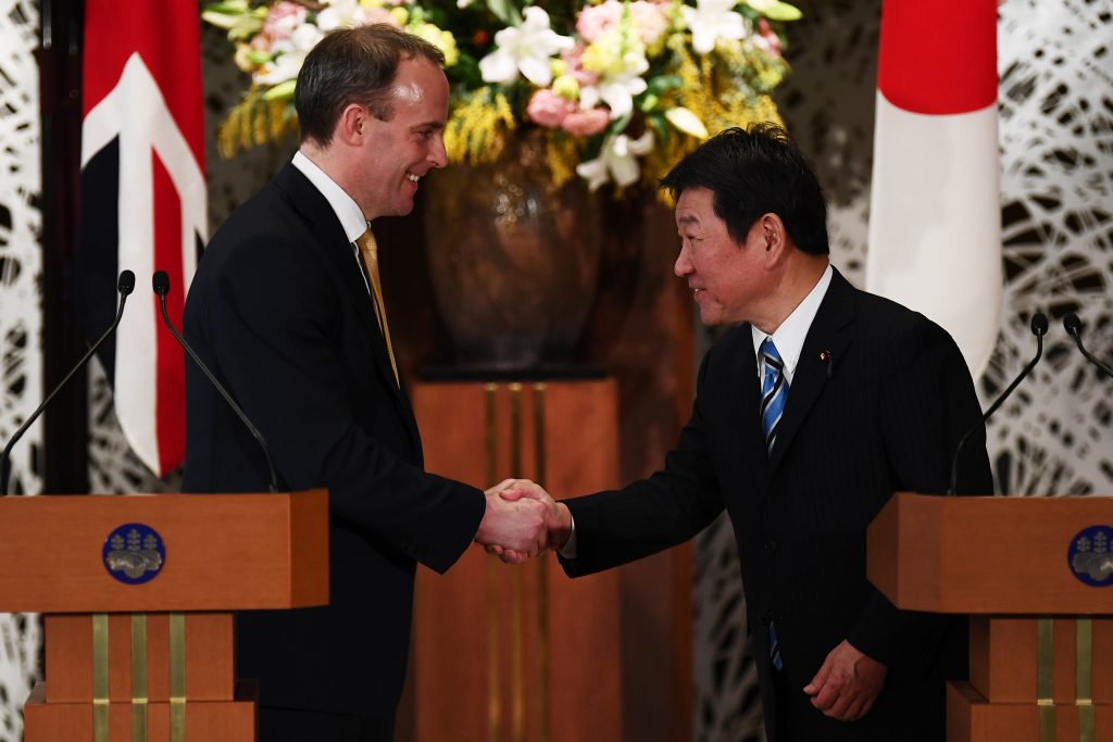 British Foreign Secretary Dominic Raab (L) and Japan's Foreign Minister Toshimitsu Motegi (R) shake hands after a joint press conference in Tokyo on Feb. 8, 2020. (AFP)