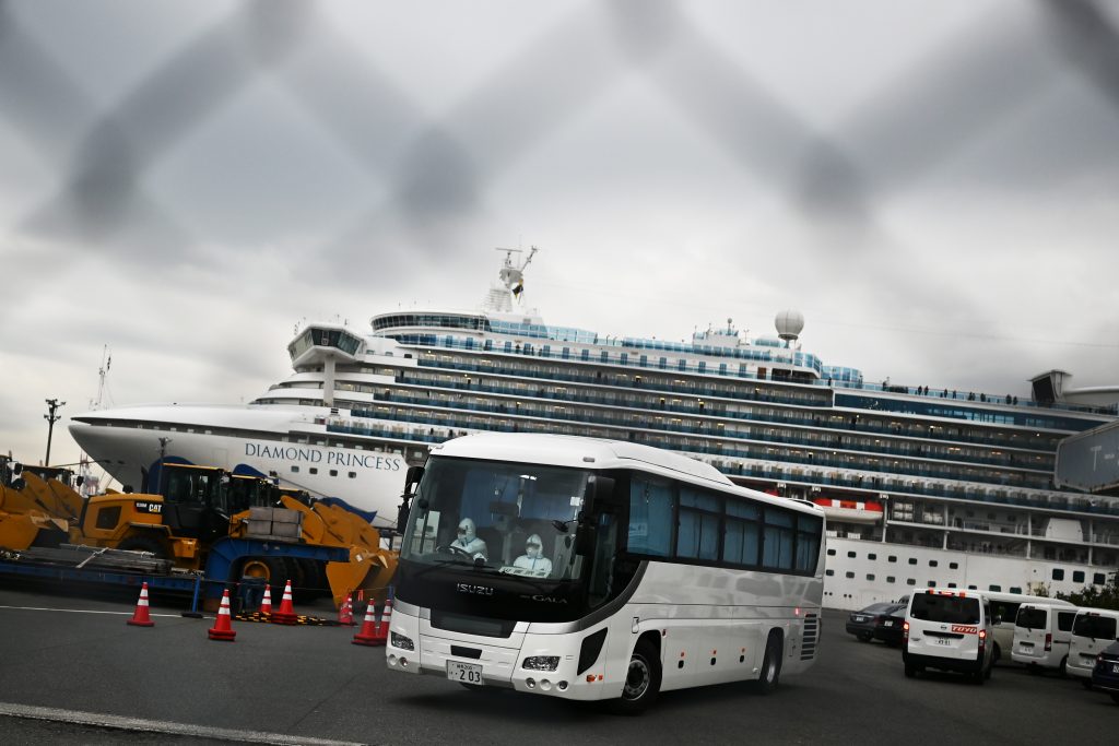 In the early hours of Monday morning, a convoy of buses driven by people in head-to-toe protective suits removed American passengers from the ship after a makeshift passport control. (AFP)