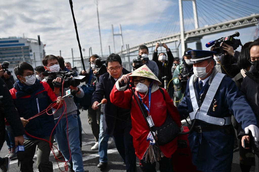 A passenger (C) leaves after dismembarking the Diamond Princess cruise ship in quarantine due to fears of the new COVID-19 coronavirus, at the Daikoku Pier Cruise Terminal in Yokohama on February 19, 2020. (AFP)