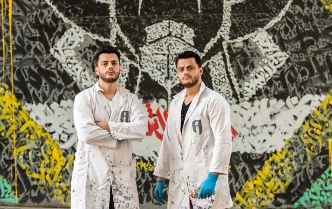 The Ashekman twins, Omar and Mohammad Kabbani stand in front of a Grendizer mural in Beirut, Lebanon. (Instagram/Ashekman) 