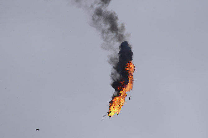 A Syrian government helicopter bursts in flames after it was shot by a missile in Idlib province on Tuesday. (AP)