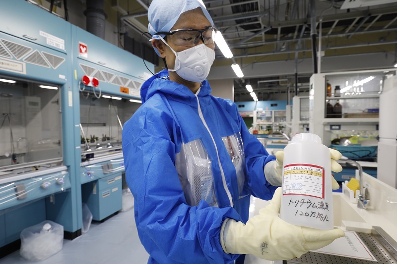 In this picture taken on October 2, 2019 a Tokyo Electric Power Company (TEPCO) researcher shows processed water where tritium remains, at a lab in Fukushima Dai-ichi nuclear plant in Okuma, Fukushima prefecture. (AFP/file)