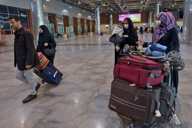 Iraqis returning from Iran wear protective masks upon their arrival at the Najaf International Airport on February 21, 2020. (File/AFP)