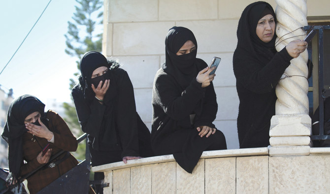 Palestinian women take photos with their mobiles during the funeral of Yazan Abu Tabikh who was killed in a raid by Israeli forces in Jenin, in the occupied West Bank, on Thursday. (AFP)
