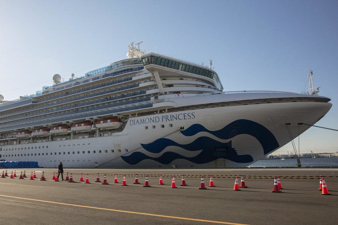 A reporter walks near the quarantined Diamond Princess cruise ship in Yokohama, near Tokyo, Tuesday, Feb. 11, 2020. (AP)