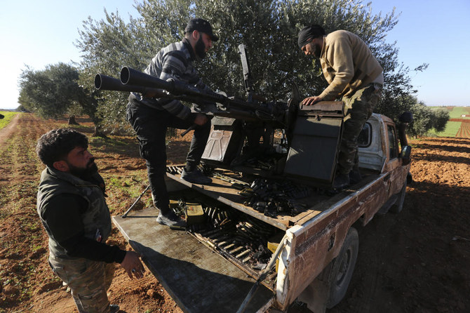 Turkey-backed Syrian fighters load ammunition at a frontline near the town of Saraqeb in Idlib province. (AP)