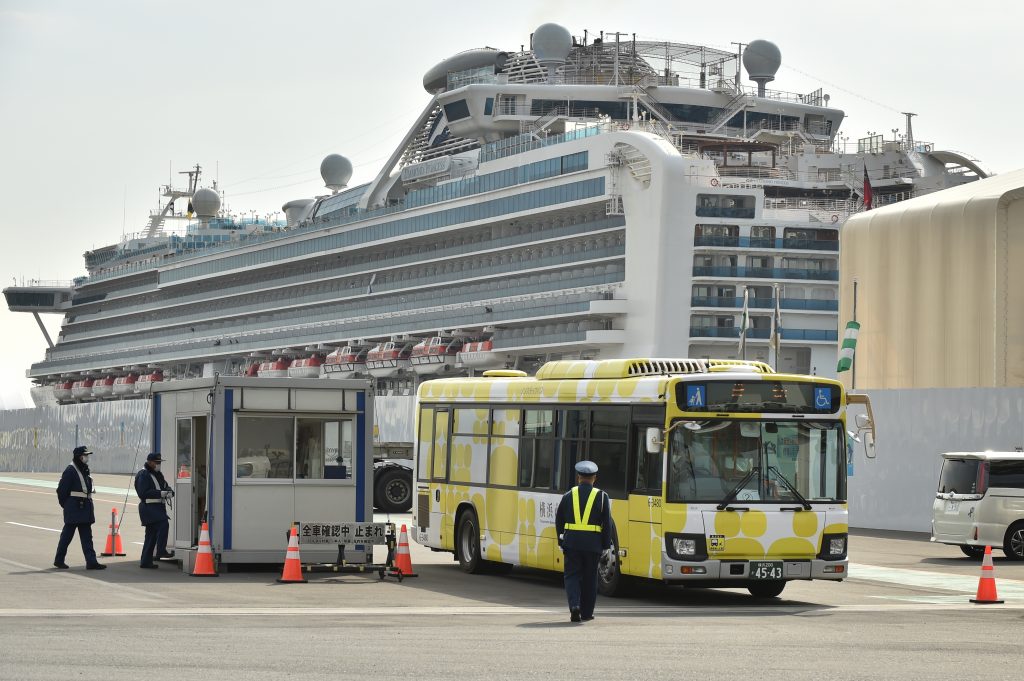 A bus carrying passengers who disembarked from the Diamond Princess cruise ship, leaves the Daikoku Pier Cruise Terminal in Yokohama on Feb. 20, 2020. (AFP)