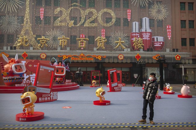 A man wearing a face mask walks through a Lunar New Year holiday display at a normally busy pedestrian shopping street in Beijing on Jan. 28, 2020. (AP)