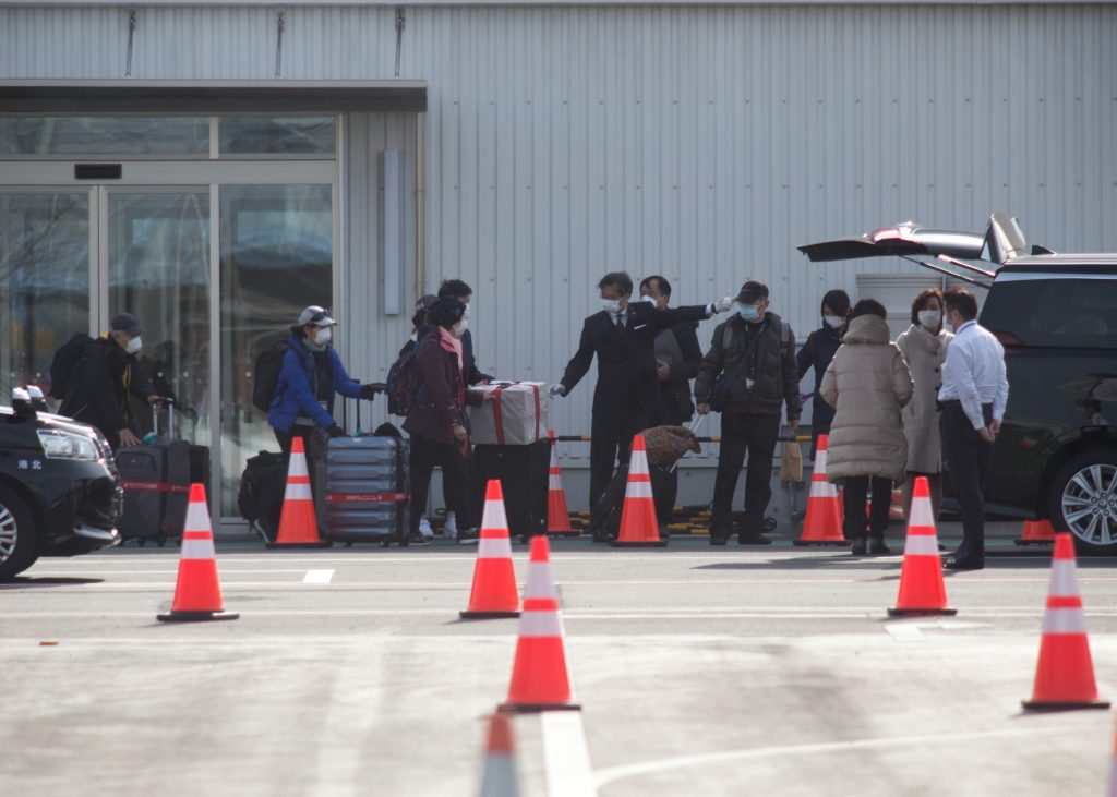 passengers (C) leaves on foot after dismembarking the Diamond Princess cruise ship quarantine, Yokohama. (AFP)