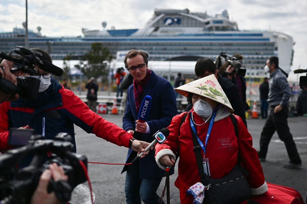 A passenger (C) leaves on foot after dismembarking the Diamond Princess cruise ship quarantine, Yokohama, Feb. 19, 2020. (AFP)