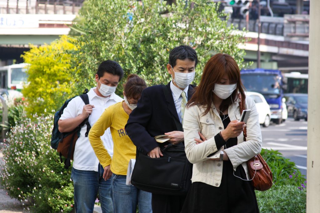 People on the street wear face masks, Kobe, Japan. (Shutterstock)